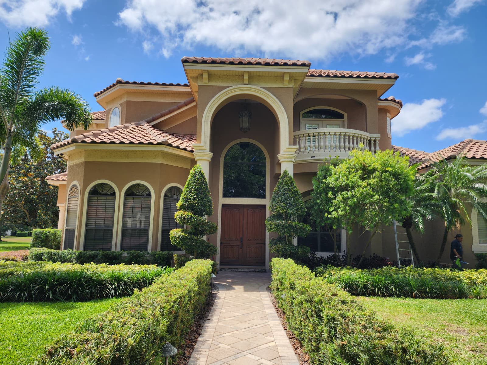 Mediterranean luxury home with foam arched entry and balcony balustrade